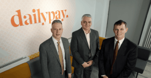 Pictured (L-R) are Ed Zaval, Chief Customer Officer, DailyPay; Mel Chittock, Interim CEO, Invest NI; Paul Hill, MD, DailyPay NI stood in front of a DailyPay logo.